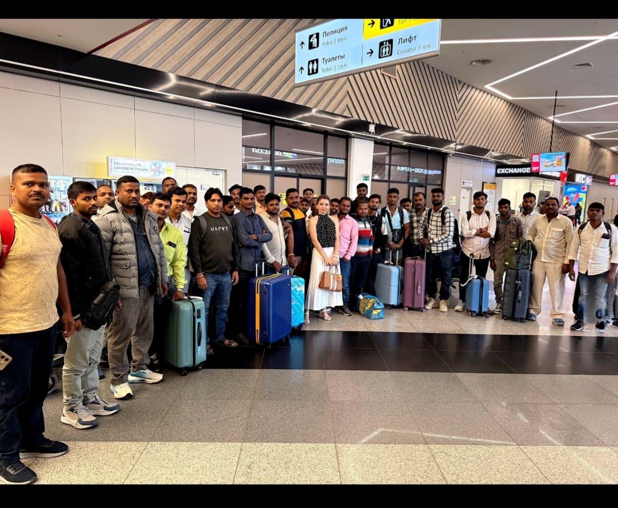 A group of deployed candidates with their luggage at an airport terminal in Russia